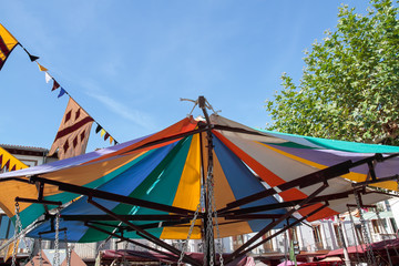 closeup of the multicolor umbrella of a carousel with the sky at background