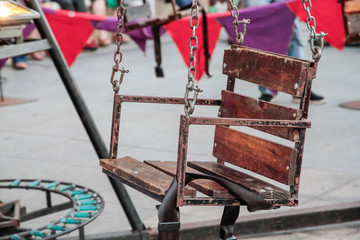 close-up of the iron and wood seat of a merry-go-round with safety belt