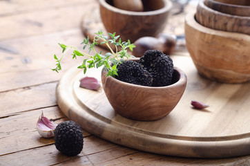 Black truffle in wooden bowl for summer truffles sauce.