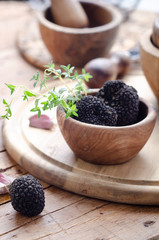 Black truffle in wooden bowl for summer truffles sauce.