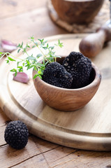 Black truffle in wooden bowl for summer truffles sauce.