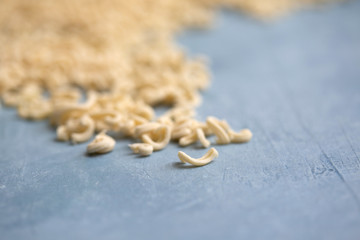 Homemade Small Macaroni Pasta Scattered on Blue Background