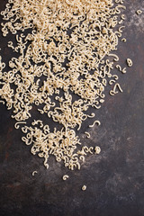 Homemade Small Macaroni Scattered on Black Background