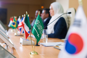 Green flag of muslim country and tricolor one on long table
