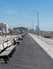 Obraz premium Boardwalk Lined with Benches with Skyline in Background