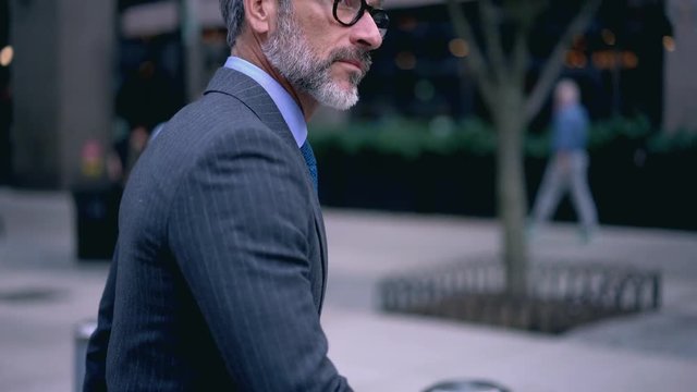 Confident mature financial director of company dressed in elegant luxury suit strolling to business meeting with colleague in office building, concept of successful lifestyle