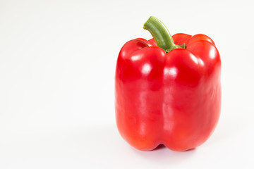 Red Bell Pepper with stem on a white background.