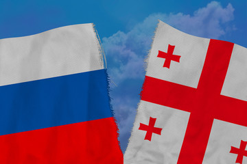 Two national flags of Russia and Georgia are torn apart by fabric, close-up, the concept of a...