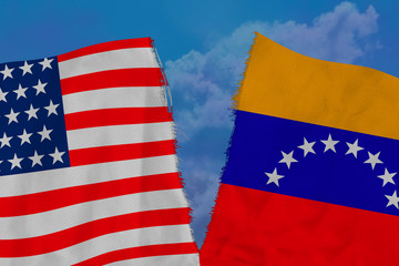 two national flags of Venezuela and America are torn apart by fabric, close-up, the concept of a...