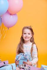 Pretty little princess with long hair holding giftbox