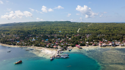 Fototapeta premium Beautiful aerial view from the beachside village near the jetty with nice sky