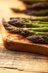 Asparagus on a cutting board. On a wooden background. Culinary background. Diet. Delicious and healthy food.