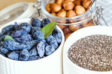 The concept of natural organic food in season. Top view. Hazelnut, granola and honeysuckle in bowls close-up