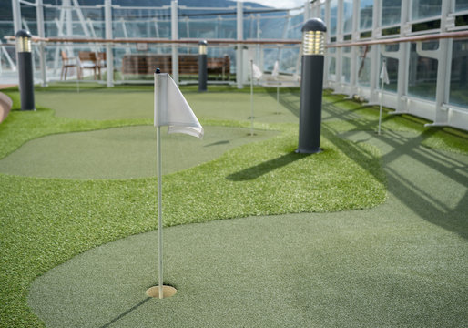 Small artificial putting green for golf practice on the deck of a cruise ship