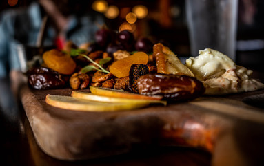 Cheese board with figs and apricots on a wooden table