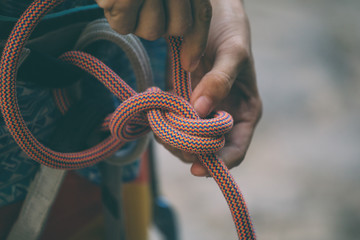 Rock climber tying a safety knot.