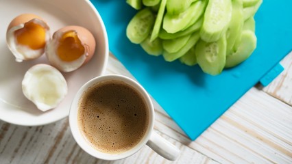 Boiled eggs with fresh cucumber salad and coffee cup breakfast set - top view breakfast food concept