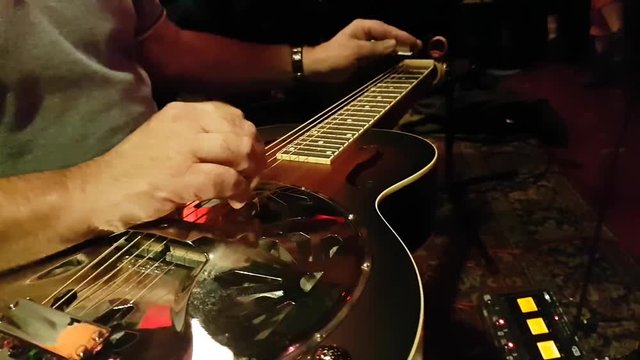 Closeup of a man playing the Dobro (Slide Guitar)