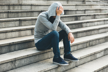 Upset woman sitting alone in city stairs