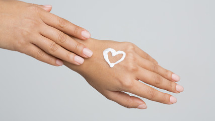 Love your Body. Female Hand with Cream in Heart Form - obrazy, fototapety, plakaty