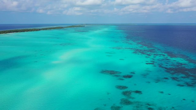 aerial drone dolly out shot over clear water of coral reefs Mexico