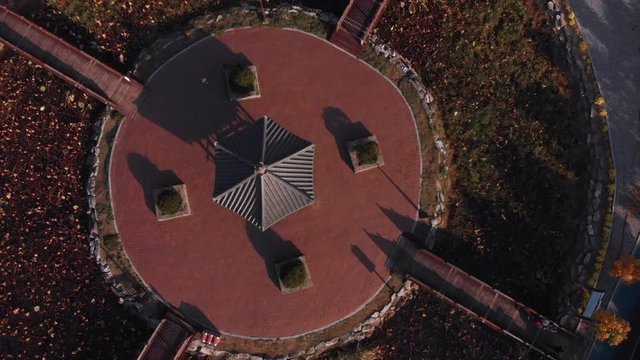 Aerial Zenithal gentle rise up above island in a park with ancient asian pavilion