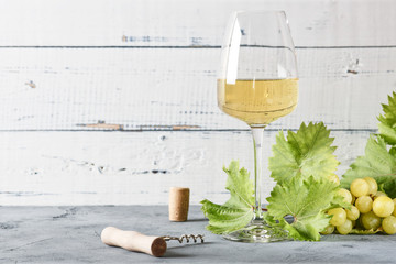Glass of white wine on vintage wooden table.