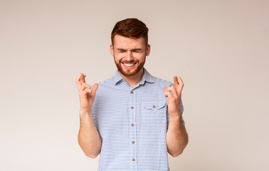 Young guy with closed eyes hopes for fortune and good luck