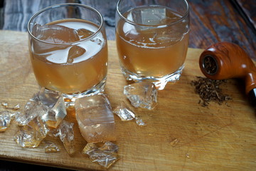 whiskey with ice on wooden background