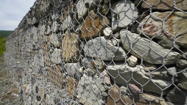 Roadside of mountain road stone gabion retaining wall prevents slope soil erosion. Road near Luchistoye / Luchyste village on southern shore of Crimea.