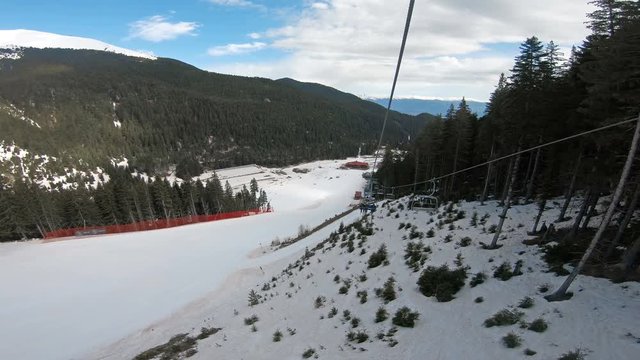 POV backwards to black Tomba slope from skier riding on ski lift in Bansko Bulgaria