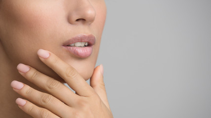 Girl with Perfect Skin and Nude Manicure Touching Chin
