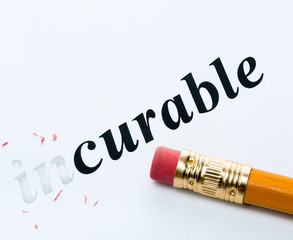 Word  incurable and curable with eraser close-up