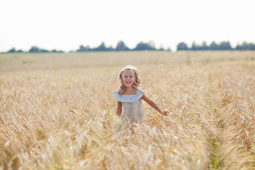 Naklejka na ściany i meble girl running on a wheat field