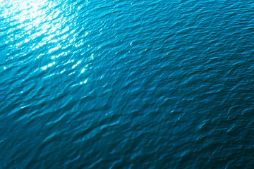 aerial view to blue water with reflectios of sun