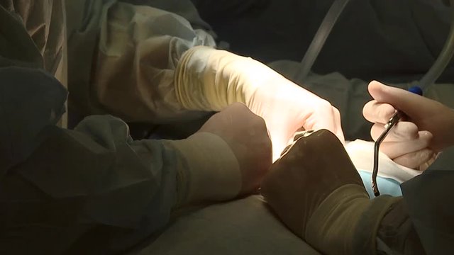Orthopedic surgeon team in the emergency room in sterile uniform performing surgery on a human spine, in Spine center. Modern medical background