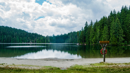 Fototapeta na wymiar Reflections on Lake Sasamat, White Pines Park, BC