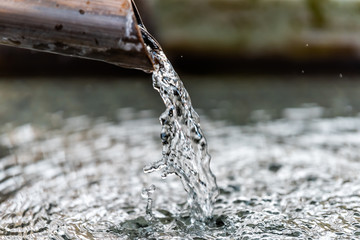 Purification fountain in Kyoto, Japan with water running from spout faucet