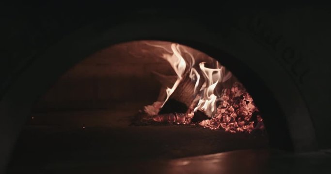 Close up shot of a wood fire brick oven burning wood. Authentic Neapolitan Pizza cooked in a wood fire oven.