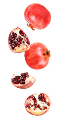 Falling in air fresh ripe whole and cut pomegranate