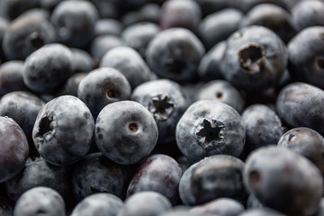 Ripe tasty blueberries and berries on a wooden table in a bowl