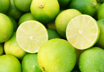 Obraz na płótnie Canvas Fresh ripe limes with water drops, lime citrus fruit close up