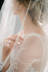 Young woman posing in a white wedding dress close up