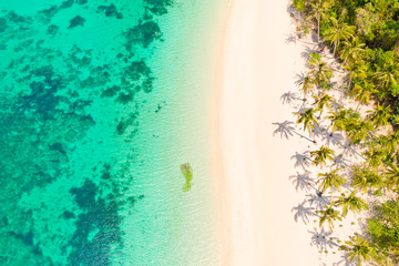 Turquoise lagune met een koraalrif en een wit strand. Strand met wit zand en palmbomen, uitzicht van bovenaf. Puka Shell Beach, Boracay Island, Filippijnen, luchtfoto.