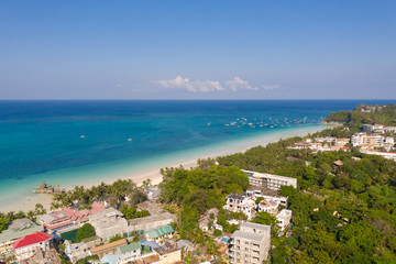 Fototapeta na wymiar Island Boracay, Philippines, view from above. White beach with palm trees and turquoise lagoon with boats. Buildings and hotels on the big island.