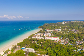 Naklejka na ściany i meble Island Boracay, Philippines, view from above. White beach with palm trees and turquoise lagoon with boats. Buildings and hotels on the big island.