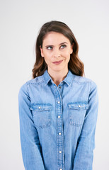 Thoughtful, young woman looking up in studio shot