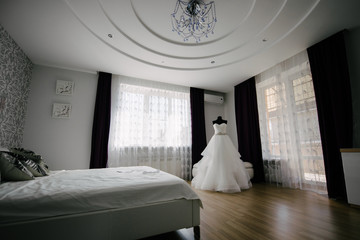 White wedding dress hanging in the bedroom. White bride dress