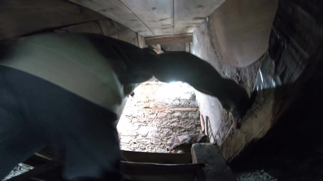 Boy walks up the old wooden stairs in stone build tower