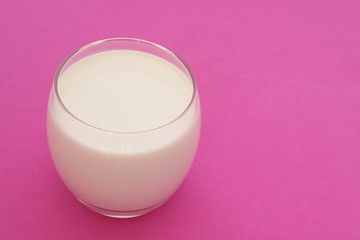 Glass of milk on pink background with room for text